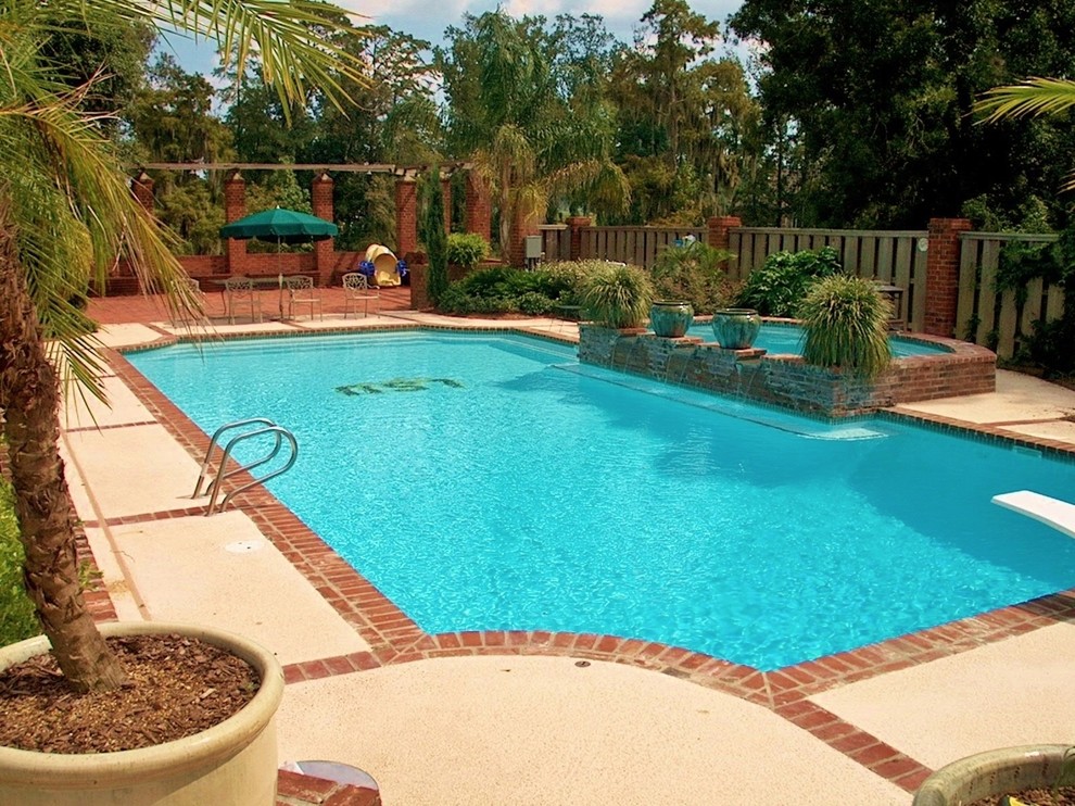 Photo of a traditional backyard rectangular pool in Other with a water feature.