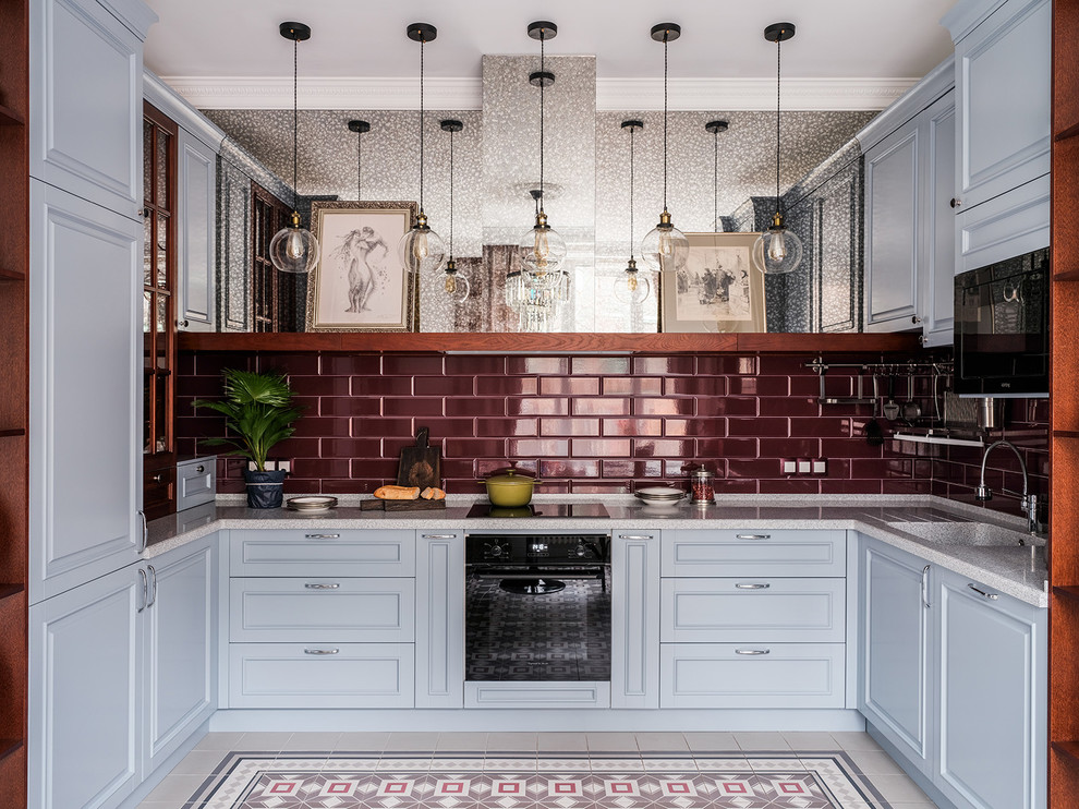 Inspiration for a mid-sized traditional u-shaped eat-in kitchen in Moscow with an integrated sink, raised-panel cabinets, grey cabinets, solid surface benchtops, red splashback, ceramic splashback, porcelain floors, no island, multi-coloured floor and black appliances.