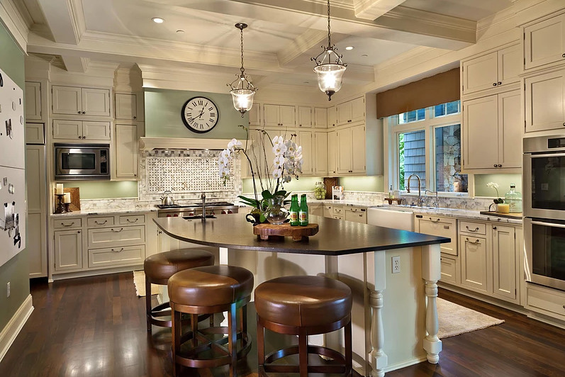 Example of a large transitional l-shaped dark wood floor and brown floor kitchen design in Seattle with a farmhouse sink, beaded inset cabinets, beige cabinets, quartzite countertops, paneled appliances and an island