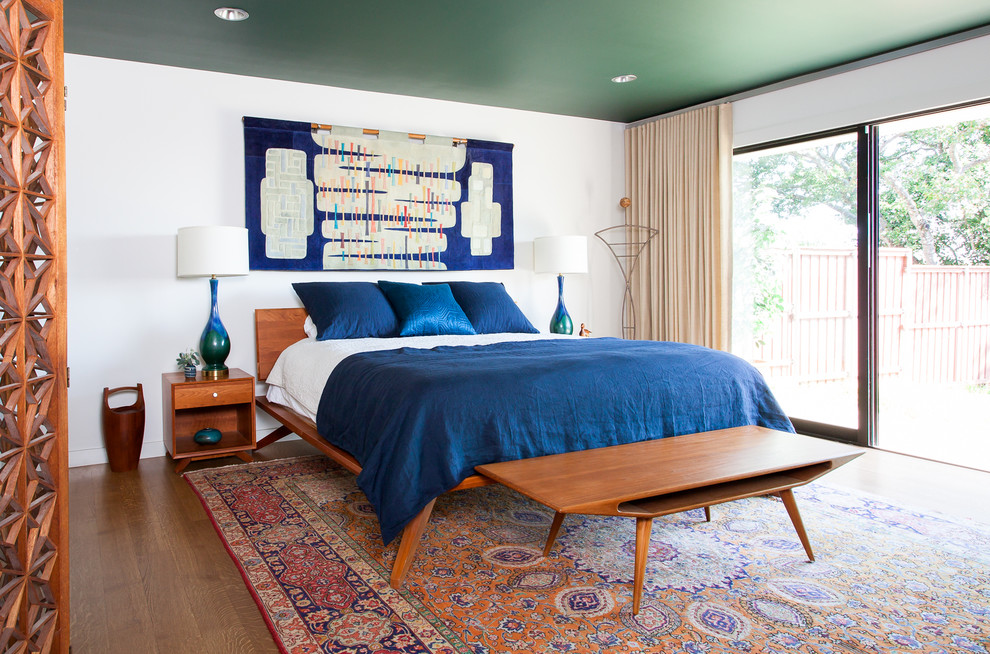 Inspiration for a midcentury bedroom in Austin with white walls and dark hardwood floors.