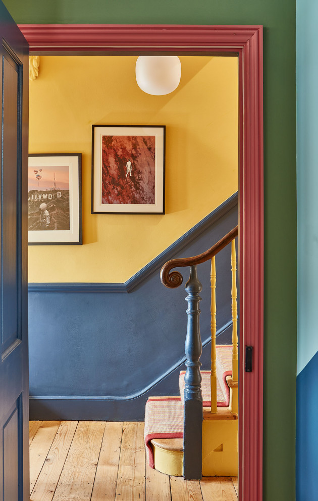 Inspiration for an eclectic carpeted straight staircase in London with carpet risers and wood railing.