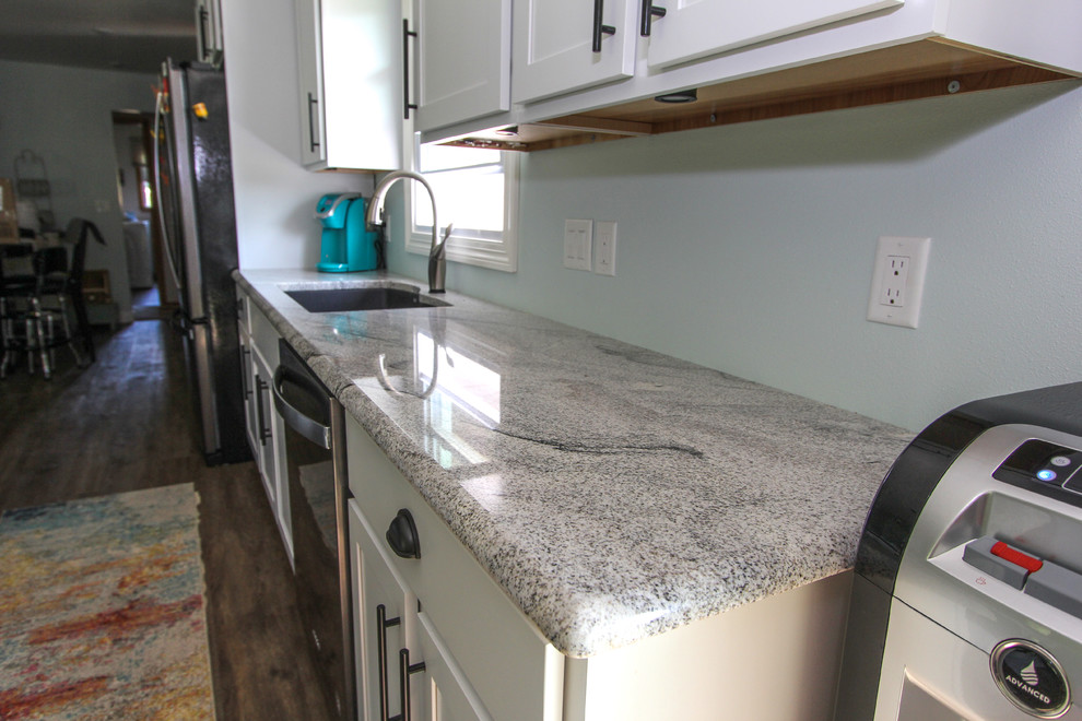 Mid-sized transitional single-wall laminate floor and brown floor open concept kitchen photo in Minneapolis with an undermount sink, shaker cabinets, gray cabinets, granite countertops, stainless steel appliances, an island and gray countertops