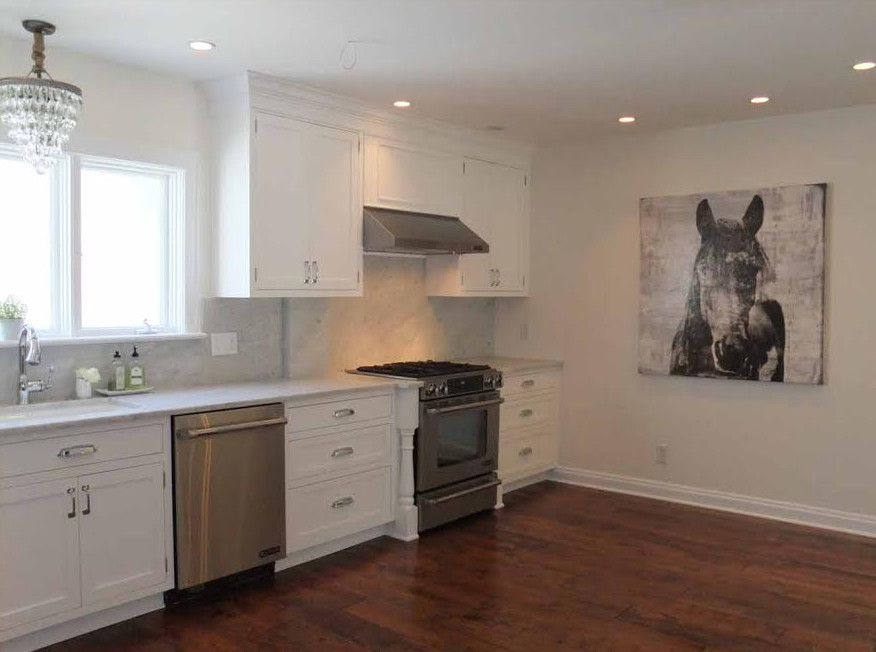 Inspiration for a large transitional l-shaped medium tone wood floor enclosed kitchen remodel in Indianapolis with an undermount sink, shaker cabinets, white cabinets, marble countertops, gray backsplash, stone slab backsplash, stainless steel appliances and no island