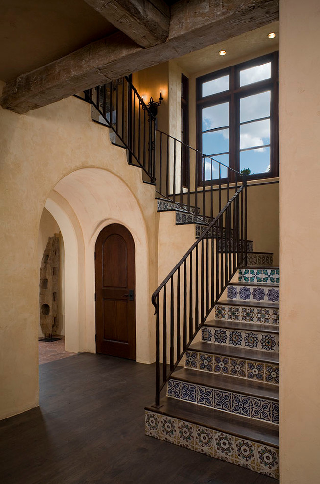 Photo of a mediterranean wood staircase in Austin with tiled risers.
