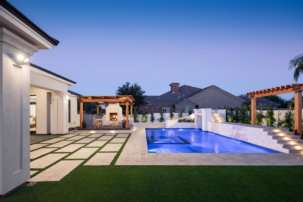Design ideas for an expansive transitional backyard rectangular natural pool in Phoenix with a hot tub and natural stone pavers.