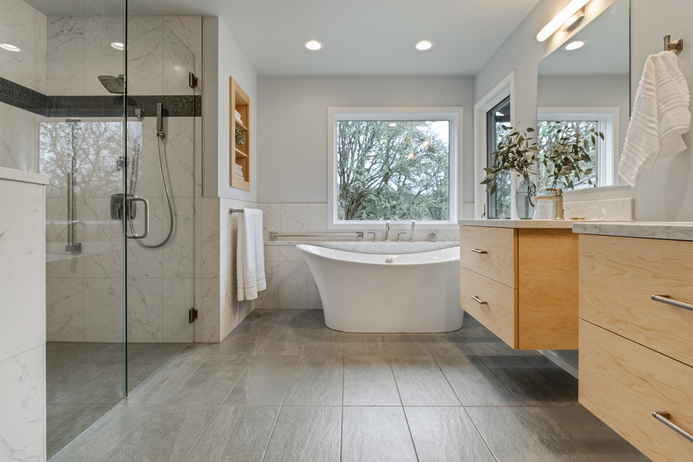 This is an example of a transitional master bathroom in Other with a freestanding tub, a curbless shower, a two-piece toilet, white tile, grey walls, an undermount sink, grey floor and a hinged shower door.