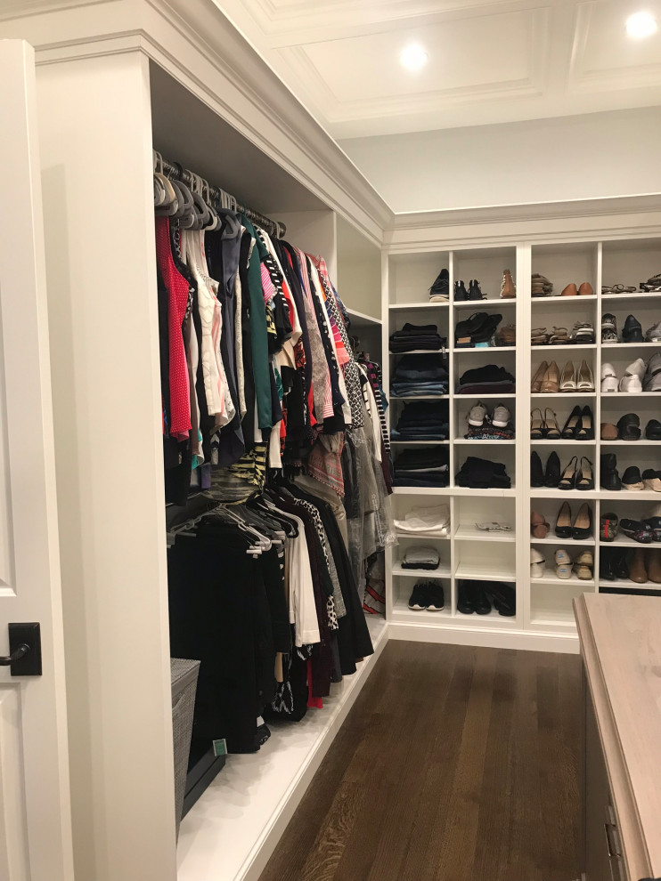 Photo of a large traditional walk-in wardrobe in New York with recessed-panel cabinets, dark wood cabinets, dark hardwood floors, brown floor and coffered.