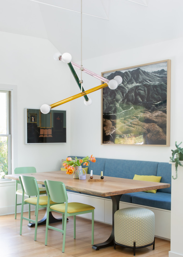 Inspiration pour une salle à manger design avec une banquette d'angle, un mur blanc, un sol en bois brun et un sol marron.