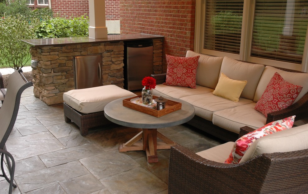 Photo of a mid-sized traditional backyard patio in Cincinnati with a fire feature, stamped concrete and a roof extension.