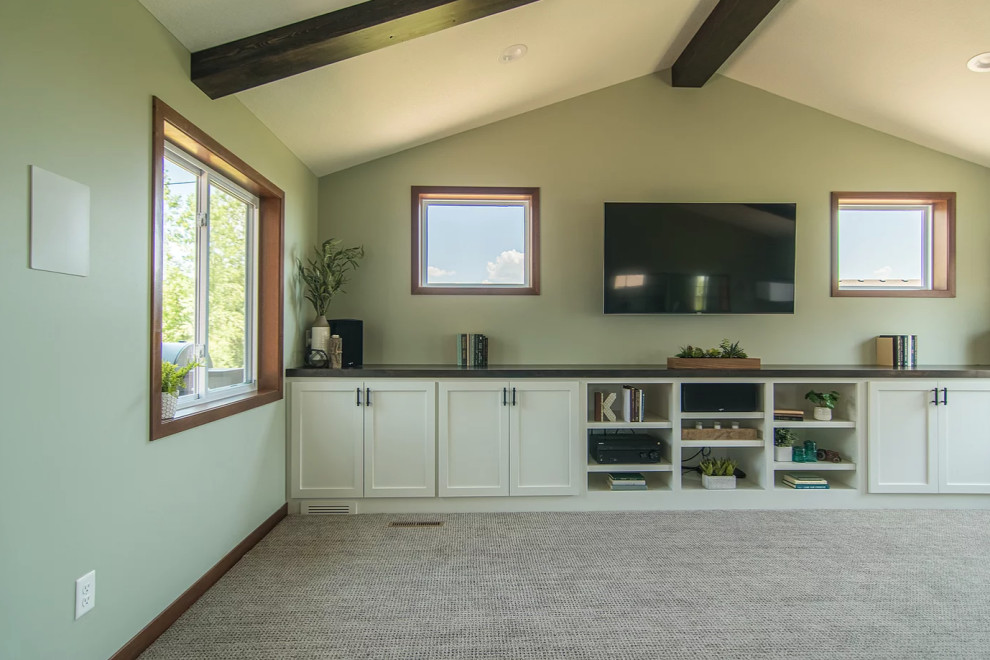Exemple d'un très grand salon chic ouvert avec un mur vert, moquette, aucune cheminée, un téléviseur encastré, un sol gris et poutres apparentes.