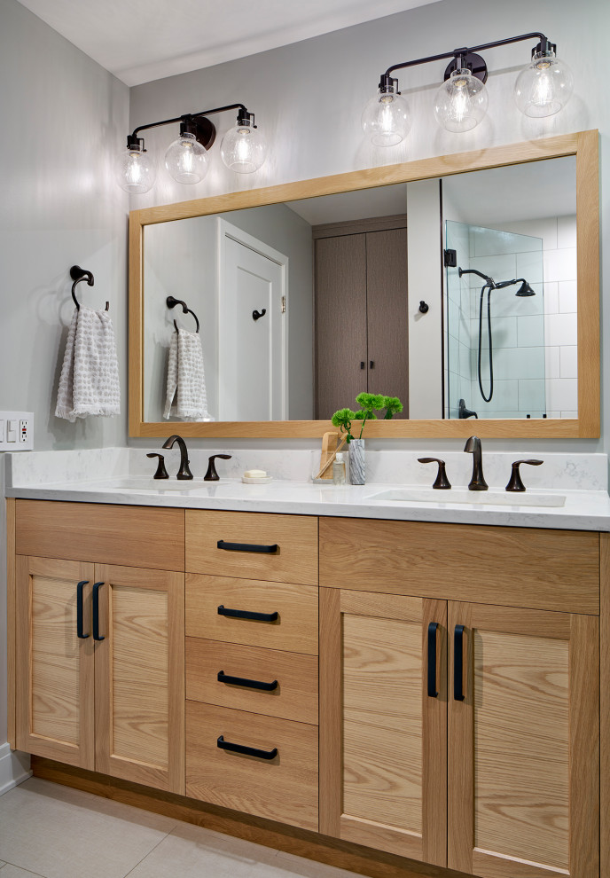 Inspiration for a mid-sized transitional master bathroom in Chicago with light wood cabinets, white walls, white floor, white benchtops, shaker cabinets, an alcove shower, porcelain floors, an undermount sink, engineered quartz benchtops, a hinged shower door, a double vanity and a built-in vanity.