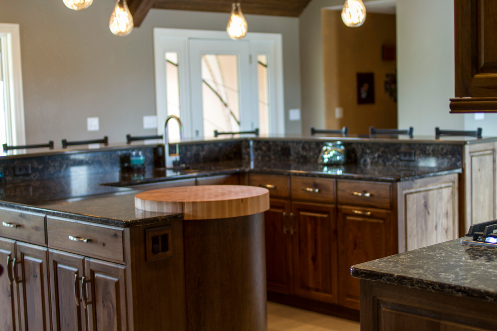 Example of a large mountain style l-shaped eat-in kitchen design in Columbus with an undermount sink, raised-panel cabinets, medium tone wood cabinets, granite countertops, multicolored backsplash, matchstick tile backsplash, stainless steel appliances and an island