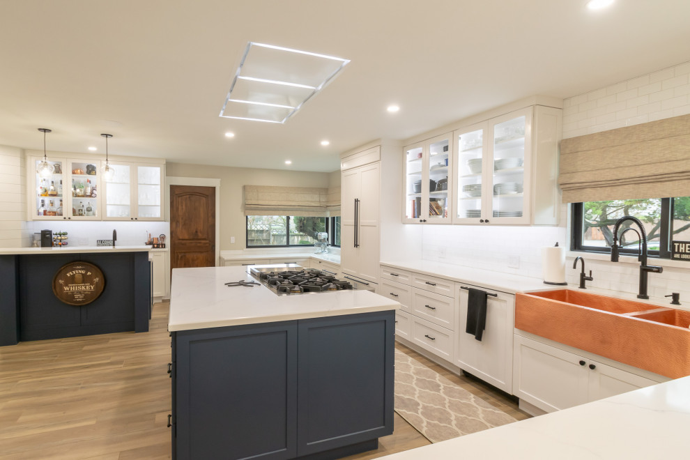 Inspiration for a huge rustic l-shaped open concept kitchen remodel in San Francisco with an undermount sink, shaker cabinets, white backsplash, ceramic backsplash, stainless steel appliances and an island