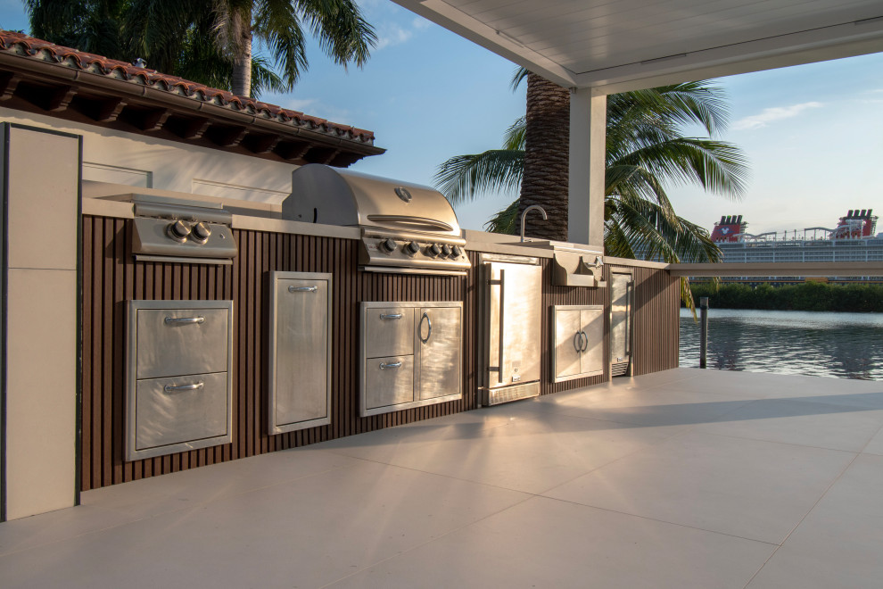 Inspiration for a medium sized contemporary back patio in Miami with an outdoor kitchen and a pergola.