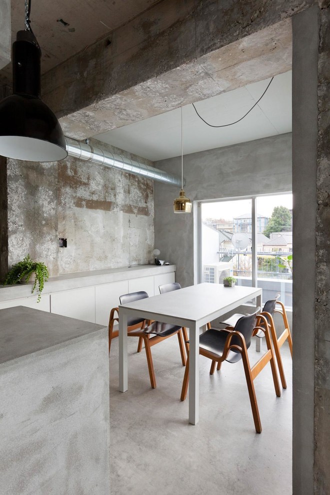 Inspiration for a small industrial kitchen/dining combo in London with grey walls, concrete floors and no fireplace.