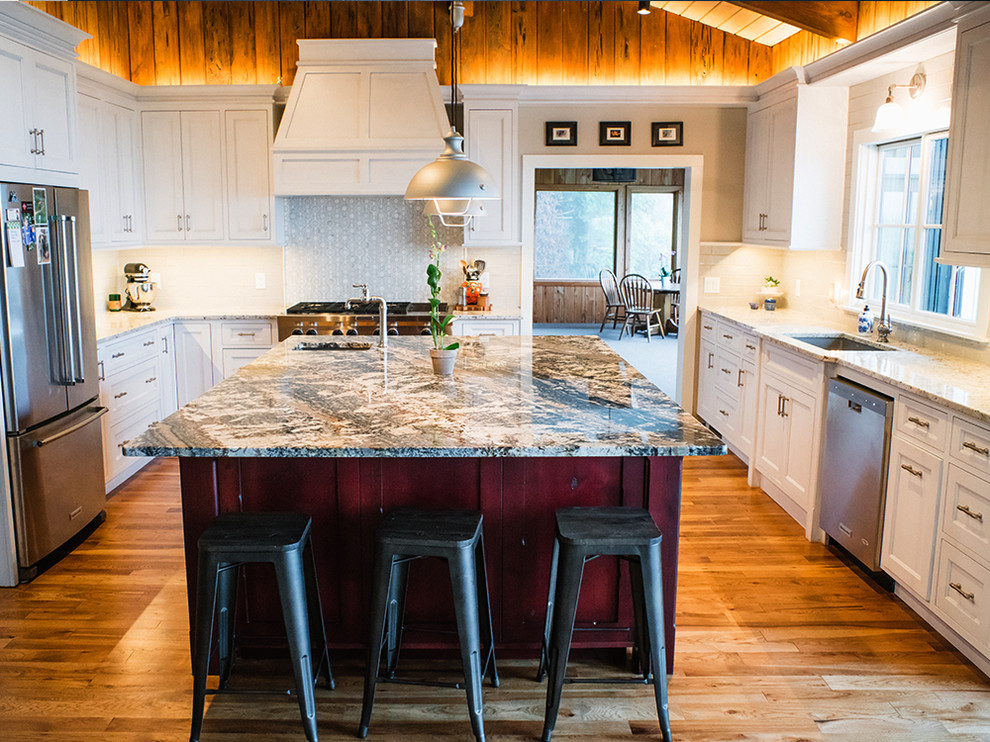 Inspiration for a large transitional u-shaped medium tone wood floor and brown floor eat-in kitchen remodel with an undermount sink, white cabinets, granite countertops, white backsplash, ceramic backsplash, stainless steel appliances, an island and shaker cabinets