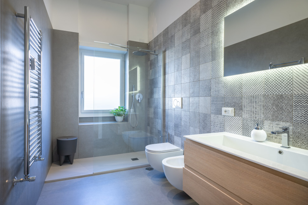 Immagine di una stanza da bagno con doccia mediterranea di medie dimensioni con ante lisce, ante marroni, piastrelle grigie, piastrelle in gres porcellanato, top bianco, un lavabo e mobile bagno sospeso