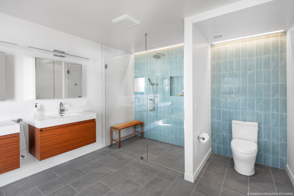 Ispirazione per una stanza da bagno padronale minimalista con ante lisce, piastrelle blu, piastrelle di vetro, pavimento con piastrelle in ceramica, top in quarzo composito, porta doccia a battente e due lavabi