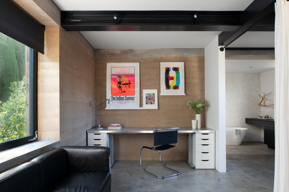 This is an example of a contemporary home office in San Francisco with brown walls, concrete floors, a freestanding desk, grey floor and exposed beam.
