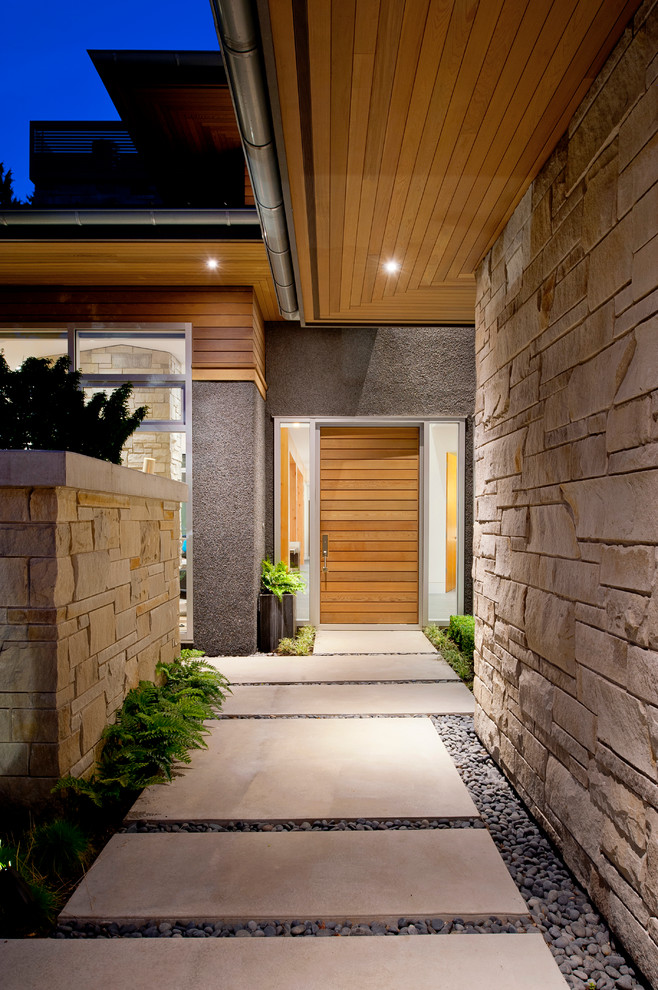 This is an example of a contemporary front door in Vancouver with a single front door and a medium wood front door.
