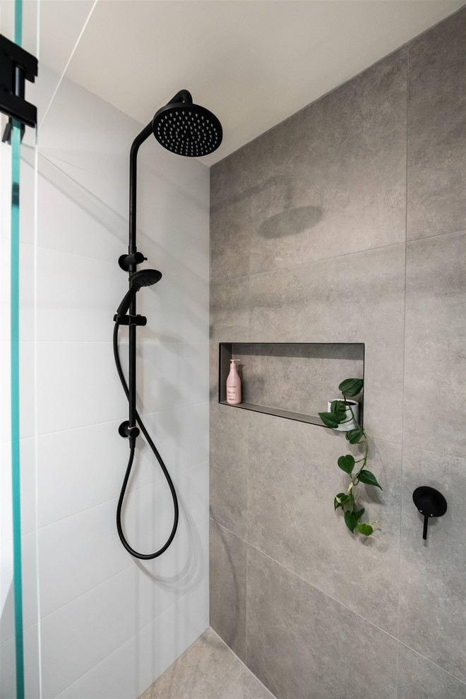 Photo of a mid-sized contemporary 3/4 bathroom in Melbourne with furniture-like cabinets, light wood cabinets, a drop-in tub, a one-piece toilet, white tile, ceramic tile, white walls, porcelain floors, a vessel sink, engineered quartz benchtops, grey floor, a hinged shower door and white benchtops.