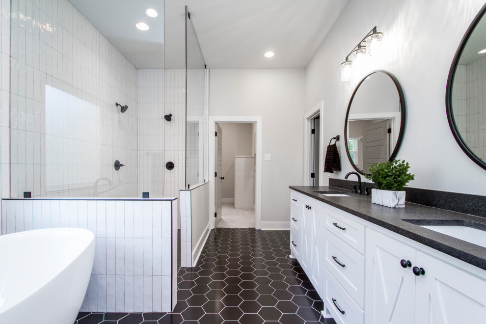 Inspiration for a mid-sized transitional master bathroom in Little Rock with recessed-panel cabinets, white cabinets, a drop-in tub, a curbless shower, a two-piece toilet, white tile, ceramic tile, grey walls, ceramic floors, an undermount sink, soapstone benchtops, black floor, an open shower and black benchtops.