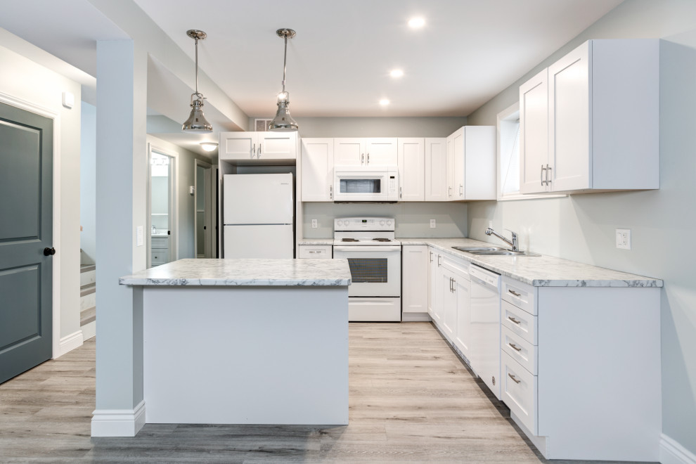 Kitchen - mid-sized modern vinyl floor and gray floor kitchen idea with shaker cabinets, white cabinets, white backsplash, ceramic backsplash, stainless steel appliances and an island