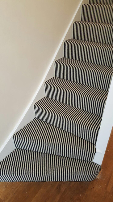 Photo of an eclectic carpeted u-shaped staircase in London with carpet risers.