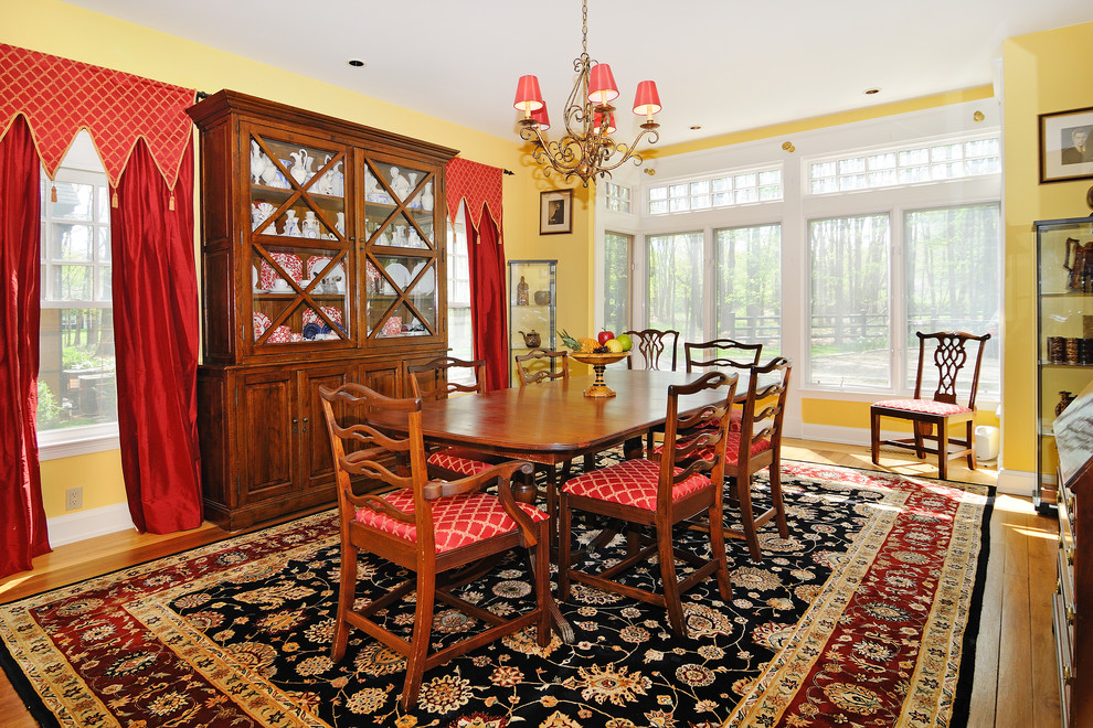 Design ideas for a traditional dining room in New York with yellow walls and medium hardwood floors.