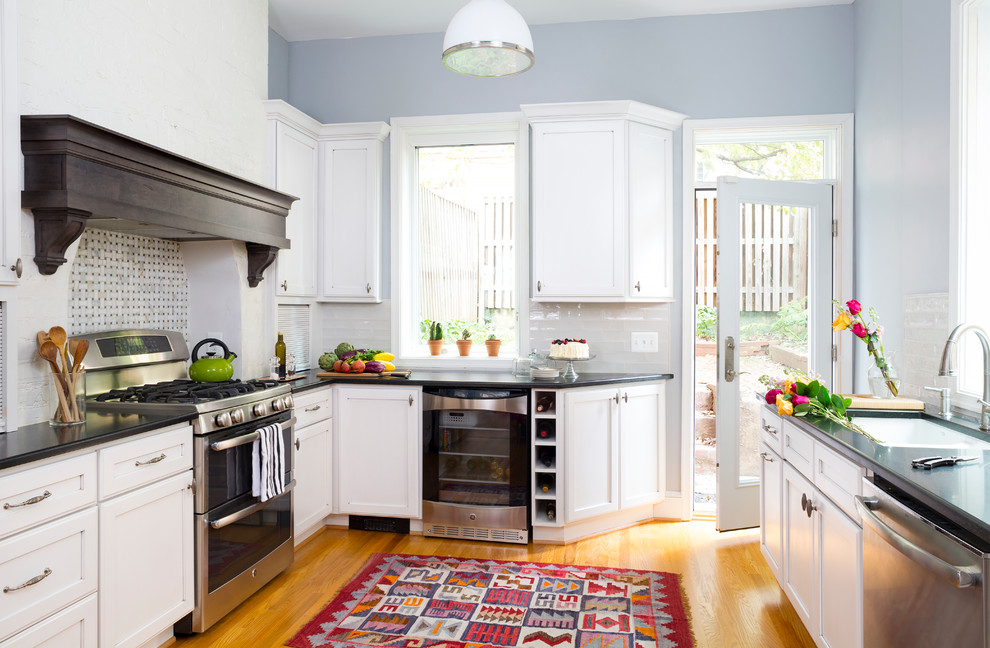 Design ideas for a transitional u-shaped kitchen in DC Metro with a single-bowl sink, recessed-panel cabinets, white cabinets, white splashback, stainless steel appliances and medium hardwood floors.