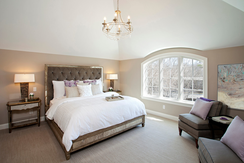 Large transitional master bedroom in Minneapolis with beige walls and carpet.