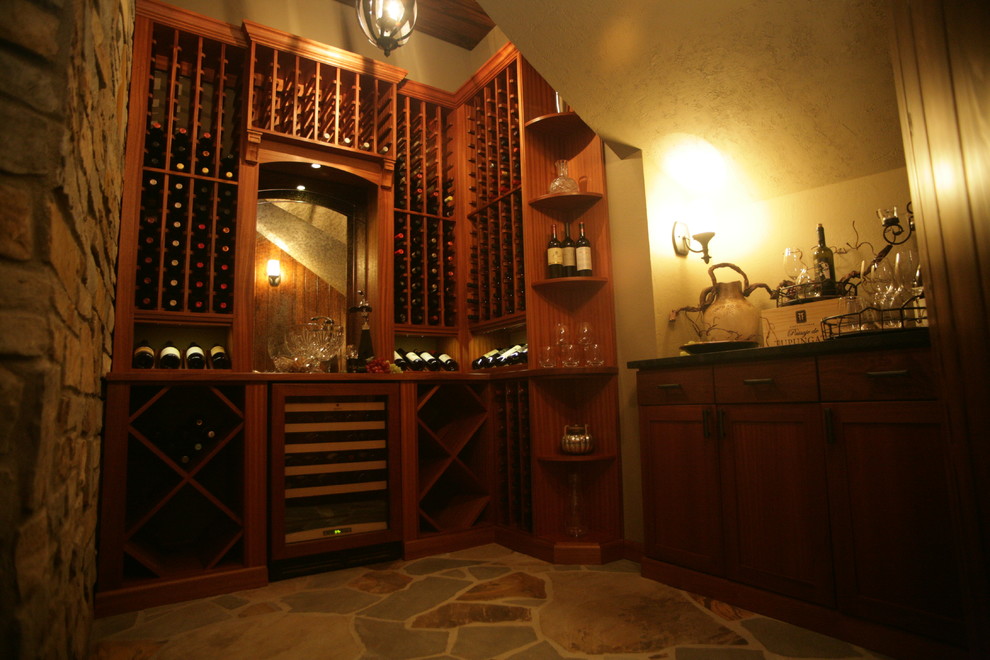Mid-sized mediterranean wine cellar in Other with travertine floors, display racks and multi-coloured floor.