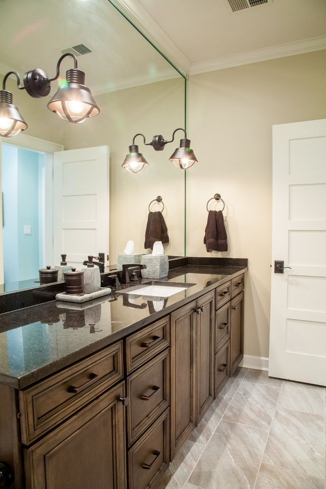 Inspiration for a mid-sized traditional kids bathroom in Nashville with recessed-panel cabinets, dark wood cabinets, a one-piece toilet, beige walls, ceramic floors, an undermount sink, marble benchtops and beige floor.