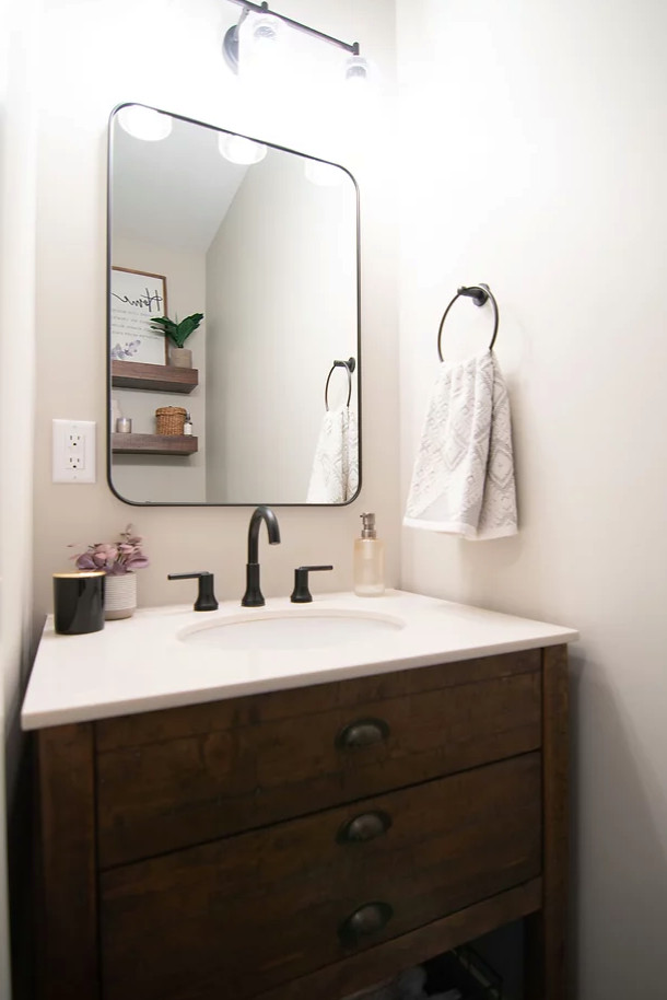 Inredning av ett klassiskt litet vit vitt toalett, med skåp i shakerstil, bruna skåp, en vägghängd toalettstol, grå väggar, klinkergolv i keramik, ett integrerad handfat, bänkskiva i kvarts och svart golv