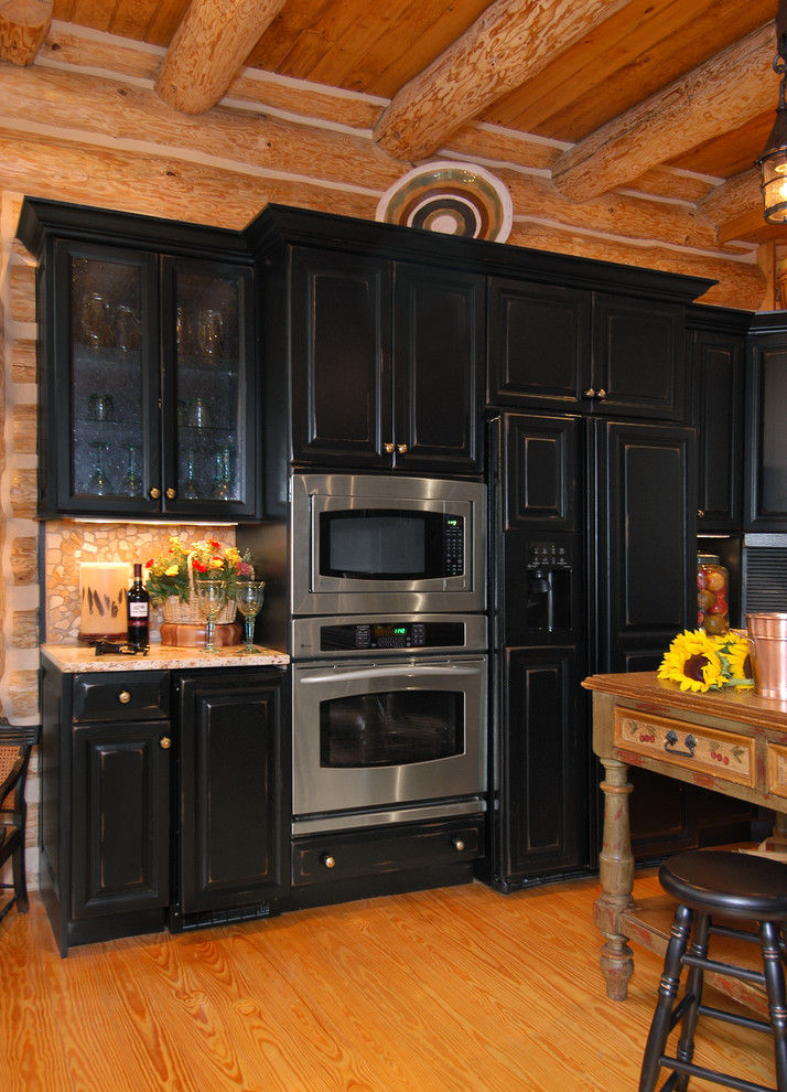 Example of a mid-sized mountain style u-shaped light wood floor eat-in kitchen design in Charlotte with raised-panel cabinets, light wood cabinets, granite countertops, beige backsplash, stone tile backsplash, paneled appliances, brown walls and an island