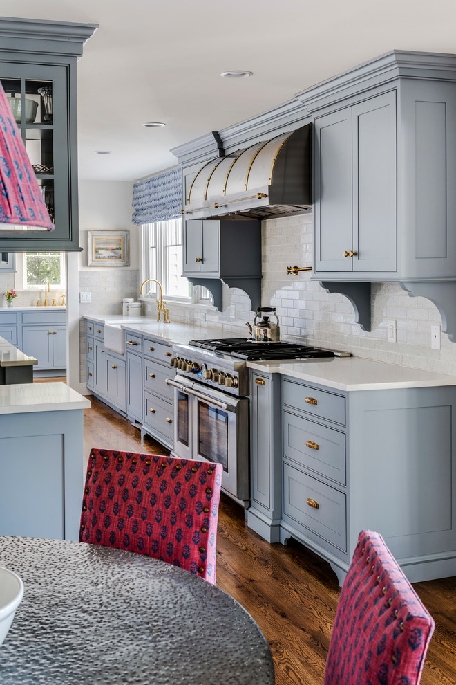 Inspiration for a large beach style u-shaped open plan kitchen in Boston with a farmhouse sink, shaker cabinets, grey cabinets, white splashback, panelled appliances, dark hardwood floors, with island and brown floor.