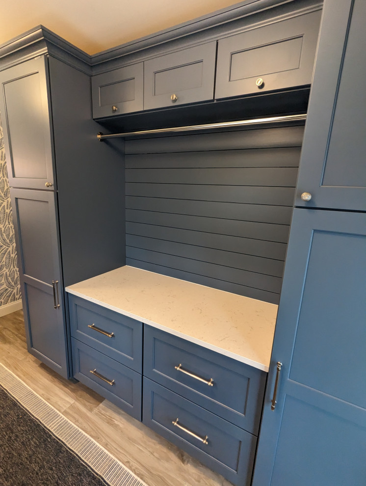 Design ideas for a medium sized contemporary galley separated utility room in Baltimore with a belfast sink, recessed-panel cabinets, blue cabinets, engineered stone countertops, blue walls, a side by side washer and dryer, grey floors, white worktops and wallpapered walls.