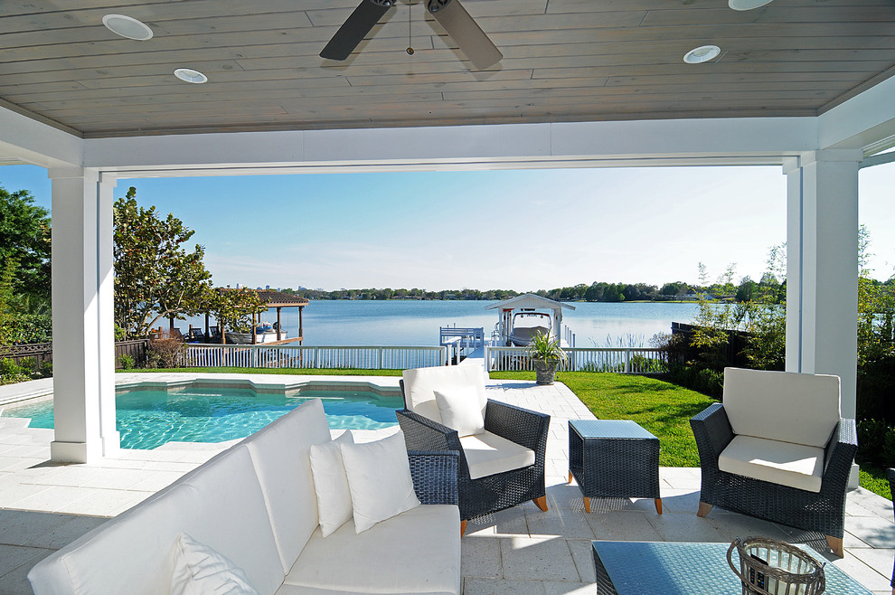 Inspiration for a beach style verandah in Orlando with concrete pavers and a roof extension.
