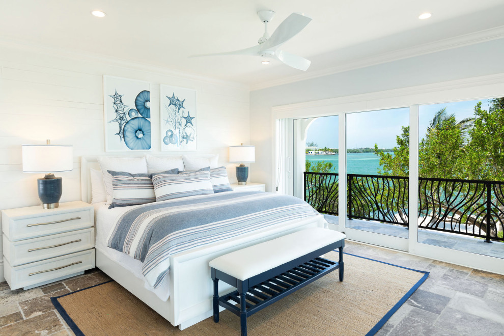 This is an example of a beach style bedroom in Miami with white walls, grey floor and planked wall panelling.
