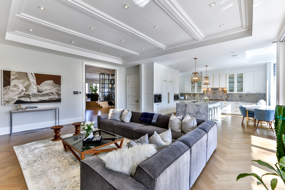 Transitional light wood floor kitchen photo in Toronto with white cabinets, marble countertops, an island and gray countertops