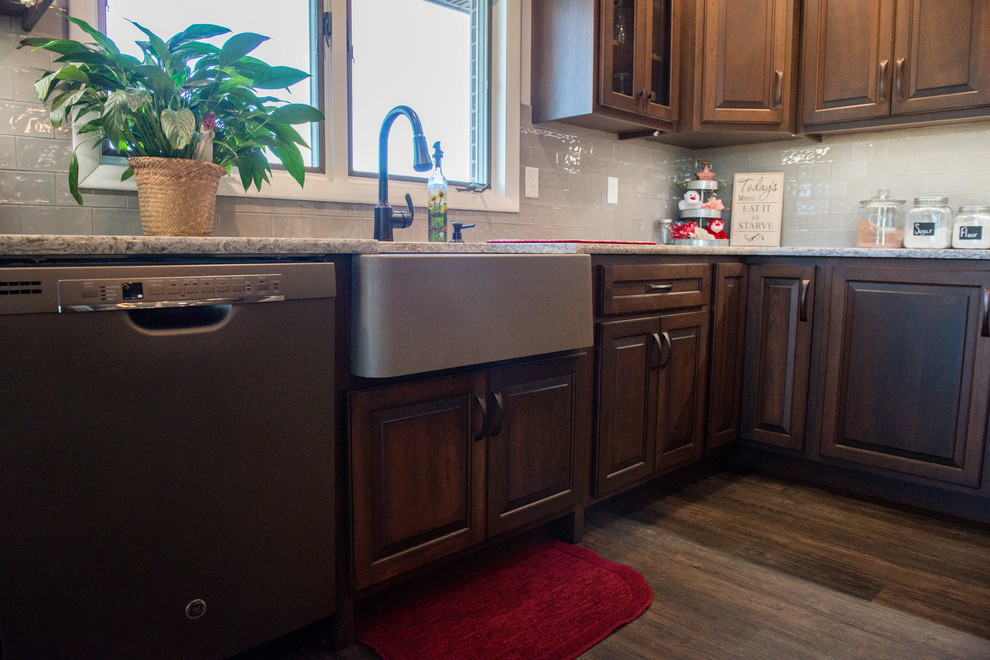 Inspiration for a huge transitional l-shaped medium tone wood floor open concept kitchen remodel with a farmhouse sink, raised-panel cabinets, medium tone wood cabinets, quartz countertops, gray backsplash, subway tile backsplash, stainless steel appliances, an island and multicolored countertops