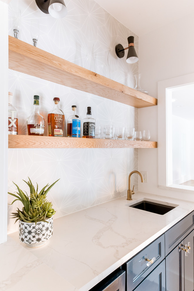 Mid-sized contemporary wet bar in Dallas with an undermount sink, shaker cabinets, blue cabinets, quartz benchtops, grey splashback, cement tile splashback, light hardwood floors and white benchtop.
