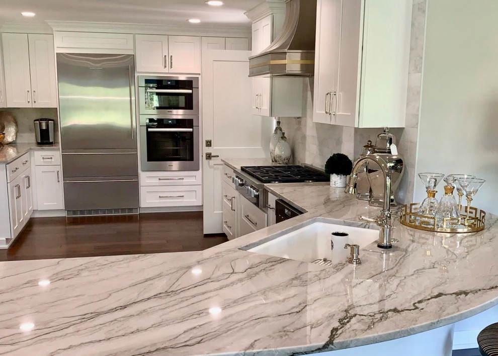 Inspiration for a mid-sized transitional l-shaped kitchen pantry in Seattle with an undermount sink, shaker cabinets, white cabinets, quartzite benchtops, white splashback, marble splashback, stainless steel appliances, with island, brown floor, grey benchtop and dark hardwood floors.