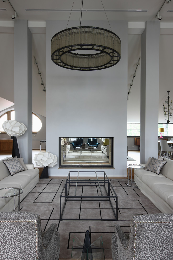This is an example of an expansive industrial formal open concept living room in Moscow with grey walls, a two-sided fireplace, a concrete fireplace surround, carpet and grey floor.