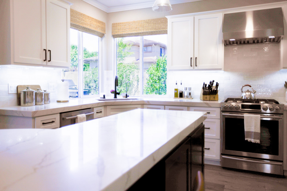 Immagine di una cucina moderna con lavello sottopiano, top in quarzo composito, paraspruzzi bianco, paraspruzzi con piastrelle in ceramica, elettrodomestici in acciaio inossidabile e top beige