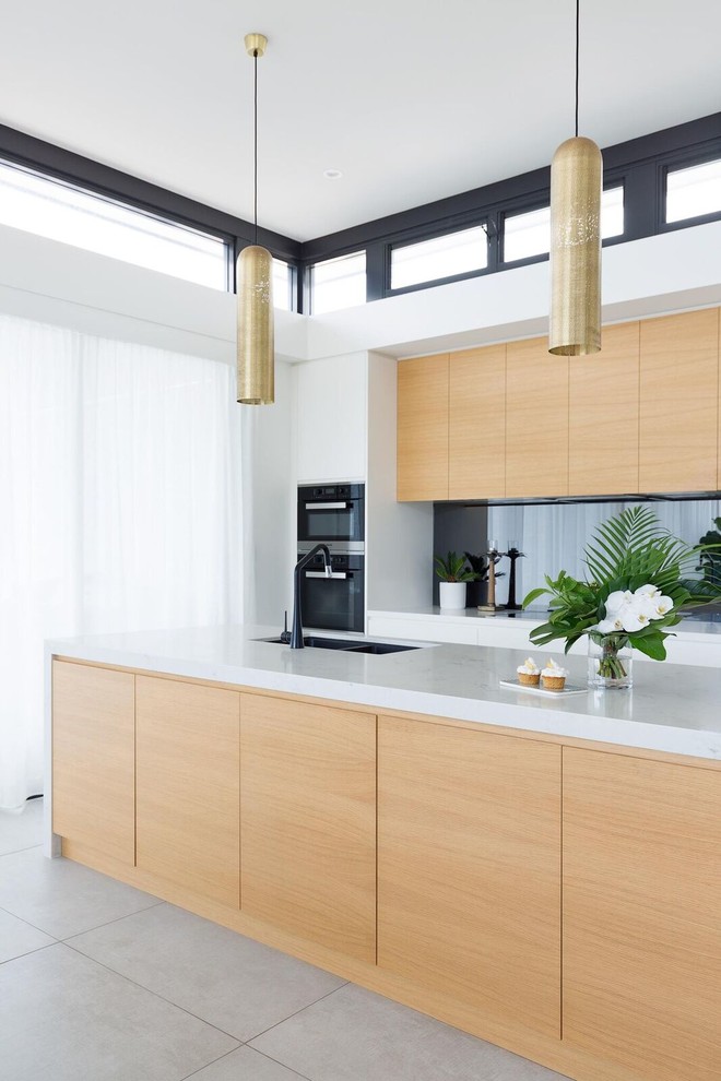 Design ideas for a contemporary galley open plan kitchen in Sydney with a drop-in sink, flat-panel cabinets, white cabinets, marble benchtops, mirror splashback, black appliances, ceramic floors, multiple islands, grey floor and multi-coloured benchtop.