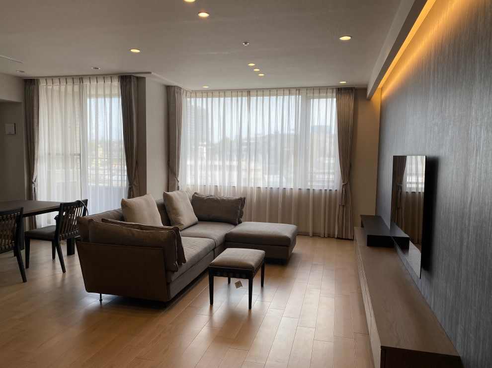 This is an example of a large open concept living room in Tokyo with grey walls, painted wood floors, a wall-mounted tv, grey floor, wallpaper and wallpaper.