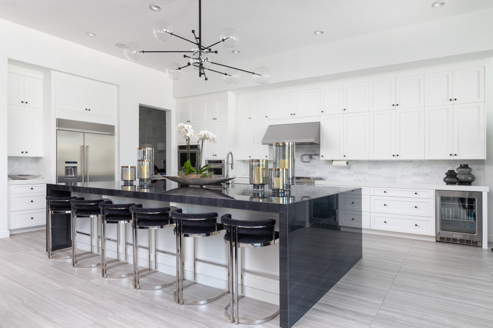 Transitional u-shaped gray floor open concept kitchen photo with an undermount sink, shaker cabinets, white cabinets, marble countertops, multicolored backsplash, marble backsplash, stainless steel appliances, an island and black countertops