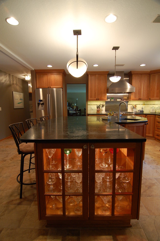 Transitional kitchen photo with soapstone countertops, stainless steel appliances and an island