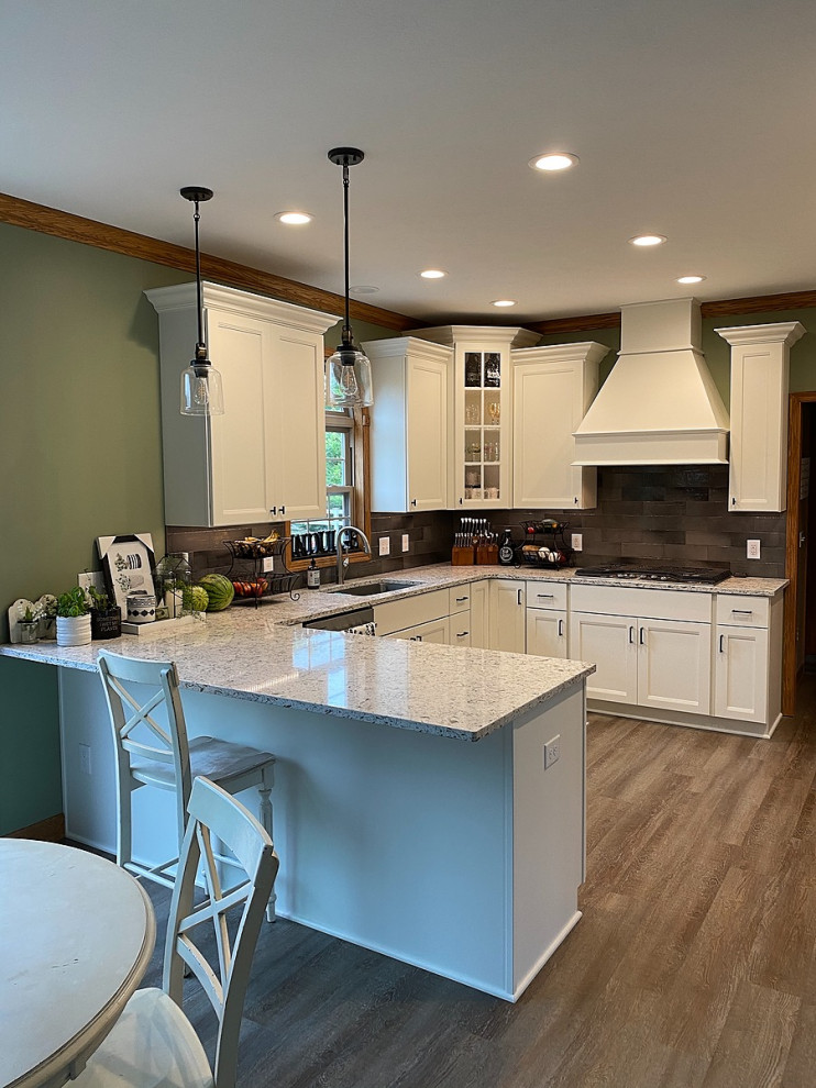 Design ideas for a large traditional l-shaped eat-in kitchen in Cleveland with an undermount sink, shaker cabinets, white cabinets, quartz benchtops, grey splashback, subway tile splashback, stainless steel appliances, vinyl floors, a peninsula, brown floor and grey benchtop.